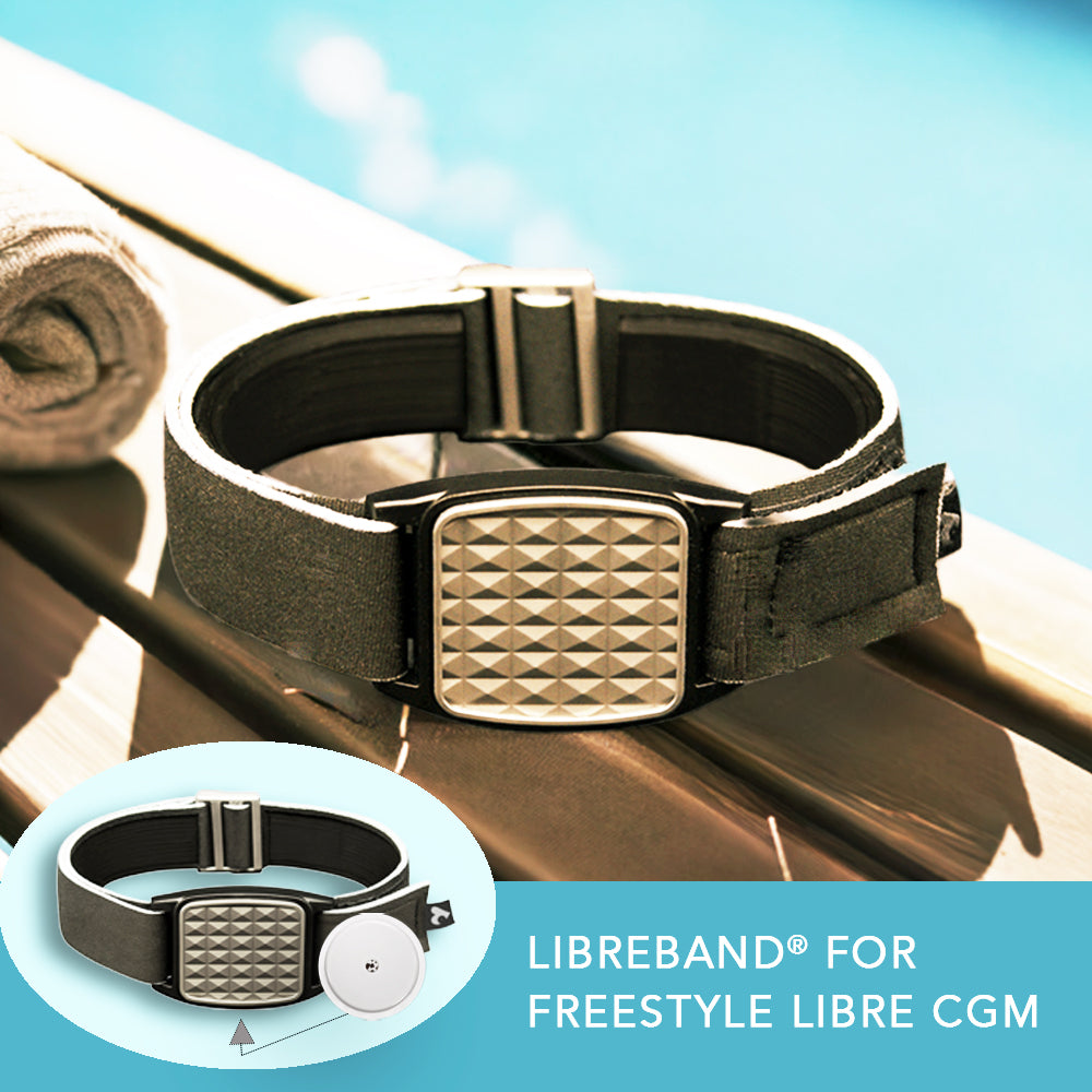 Black strap Libreband for FreeStyle Libre with silver pyramids style cover on a reflective surface with inset and pool in background.