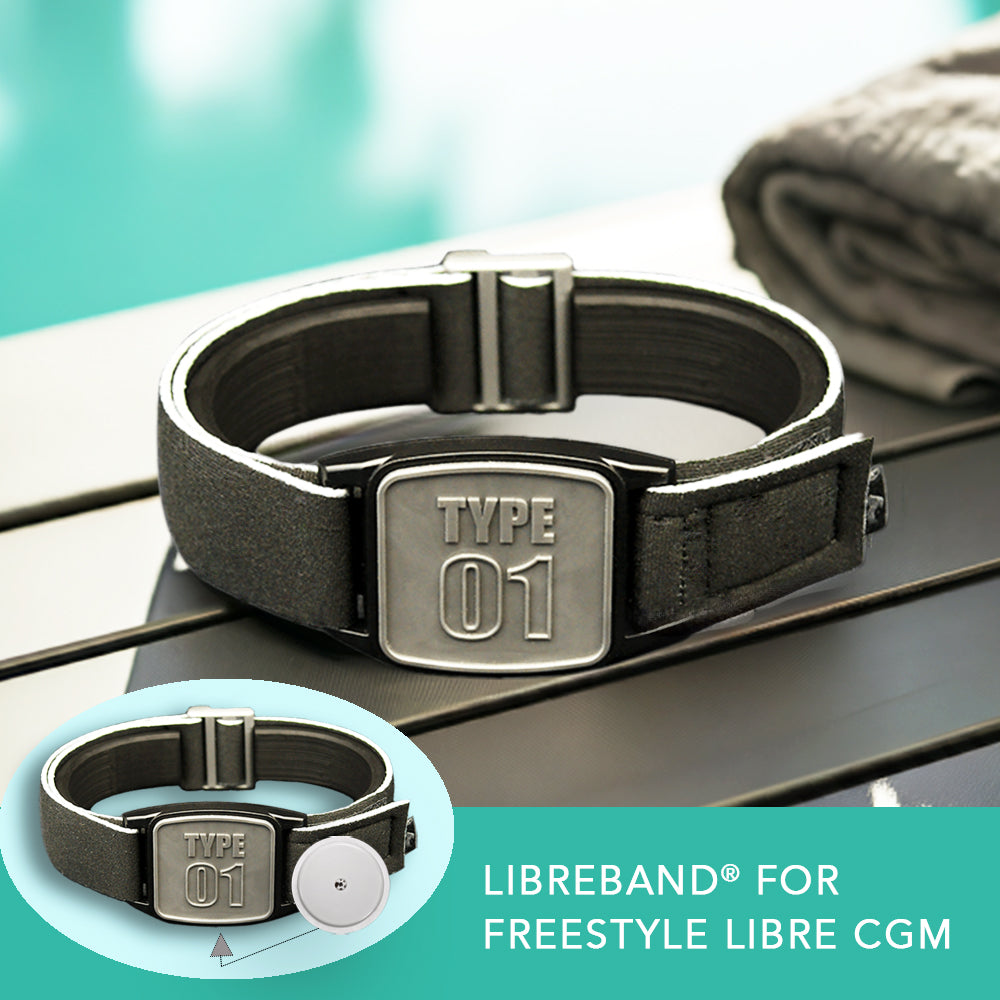 A pewter-type neoprene armband with a 'TYPE 01' design, intended for use with FreeStyle Libre 2 or Lingo CGM devices, displayed by a poolside.