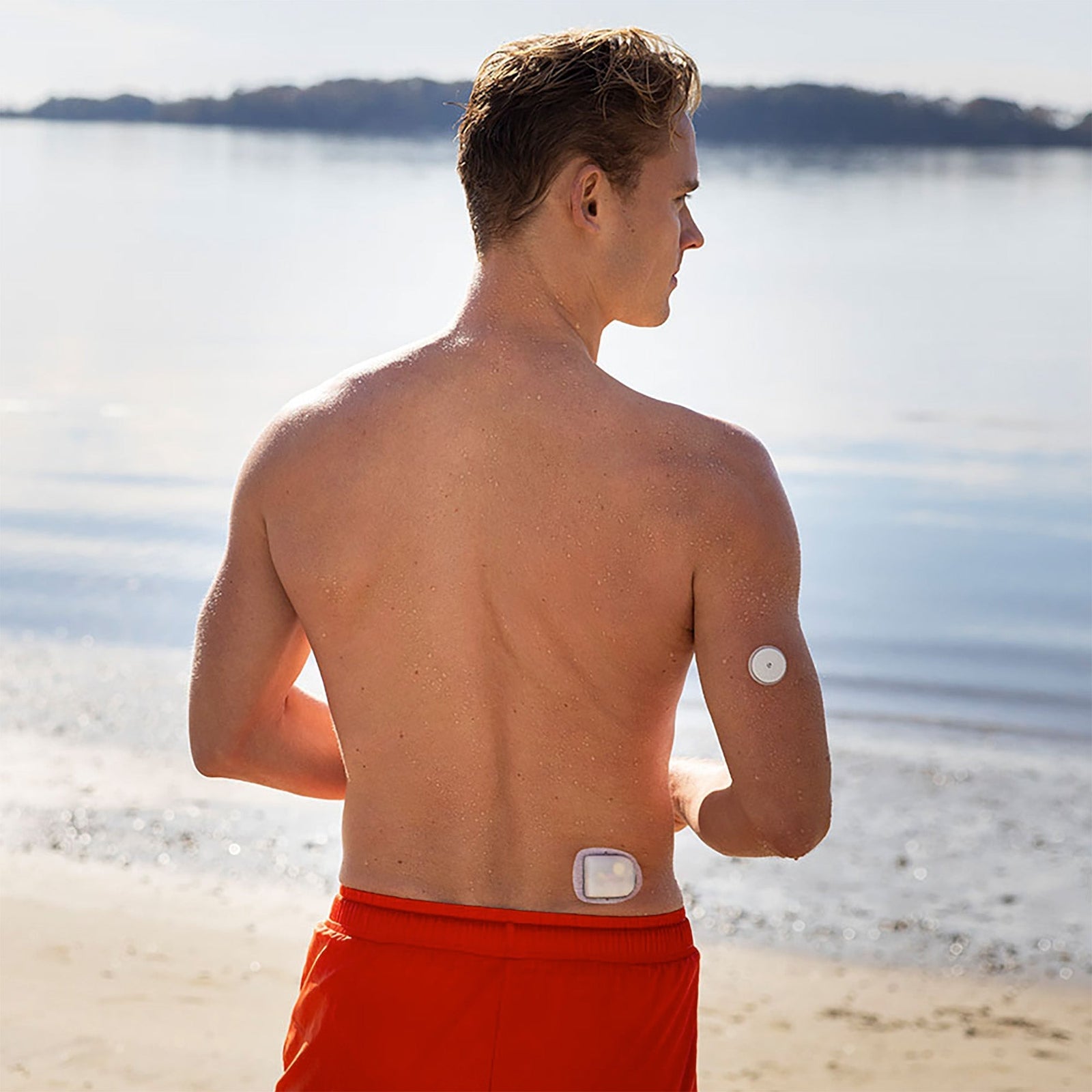 Omnipod patch pump worn on lower back with sensor worn on arm in beach setting