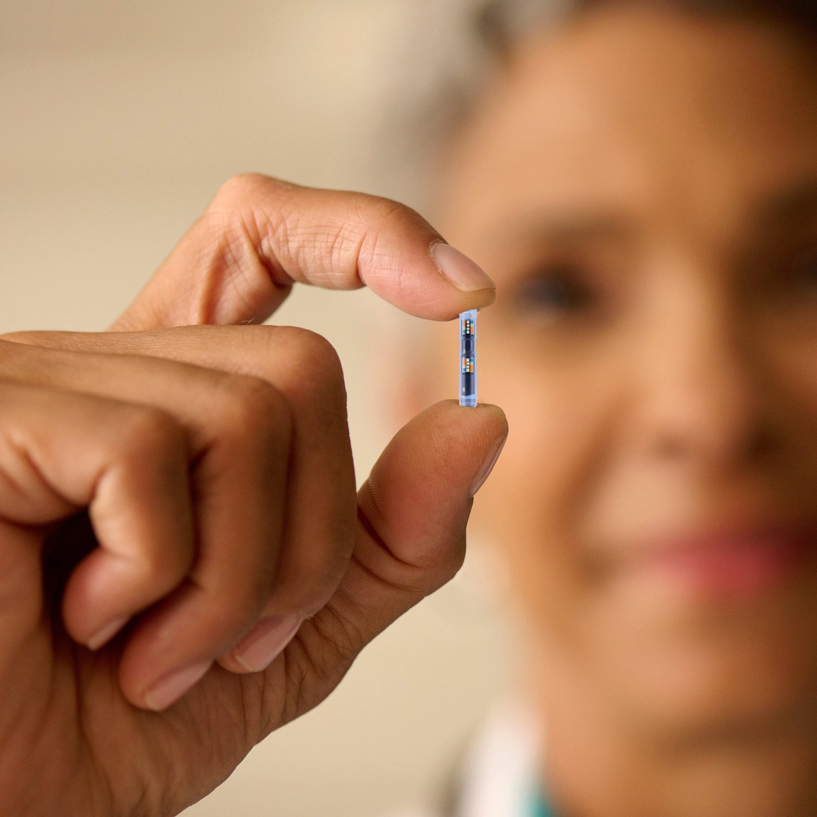 Eversense 365 implantable sensor held by healthcare professional.