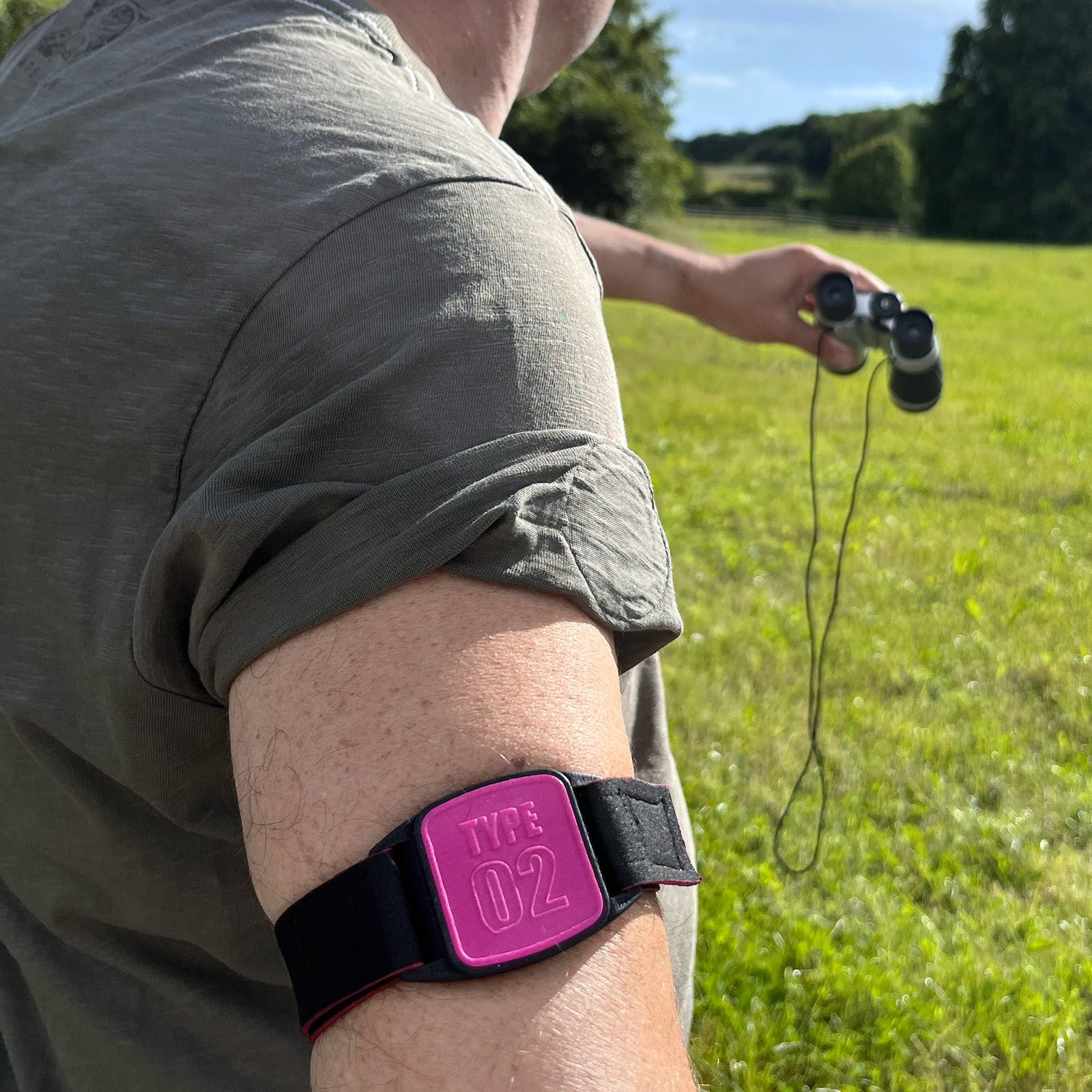 CGM armband for FreeStyle Libre 2 with magenta Type 02 cover and water-resistant neoprene strap worn on upper arm. LML2340, LML2333, LML3651, LML4511.