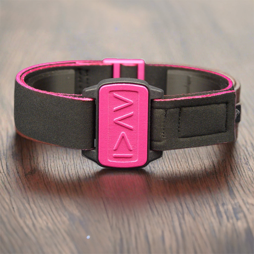 Dexband armband cover in magenta with motif I am Greater in symbols on dark wood table.