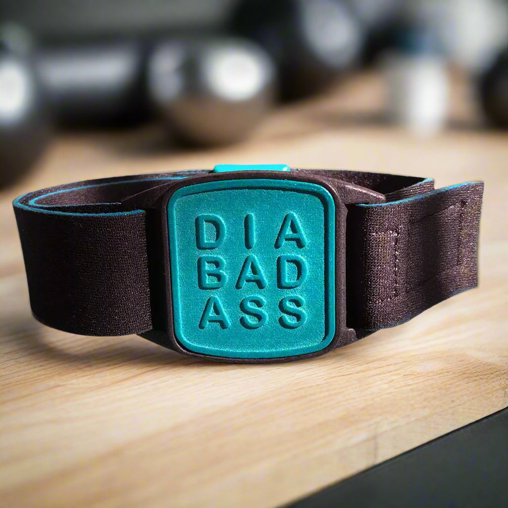 Dexband armband with black strap and teal DIABADASS cover. Shown in gym setting. LML4047, LML4054, LML4061, LML5044.