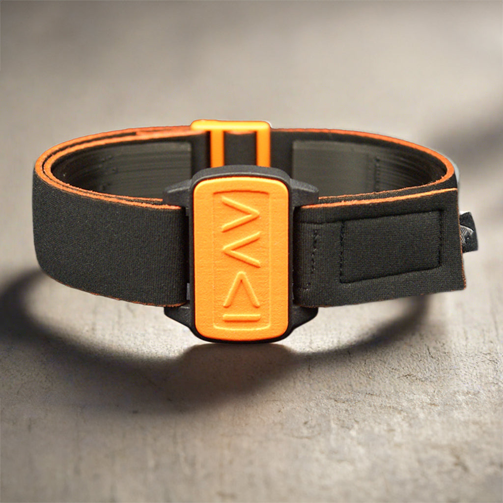 Dexband for Dexcom G6 sitting on dark wooden table, I am greater symbols on orange cover with black strap.