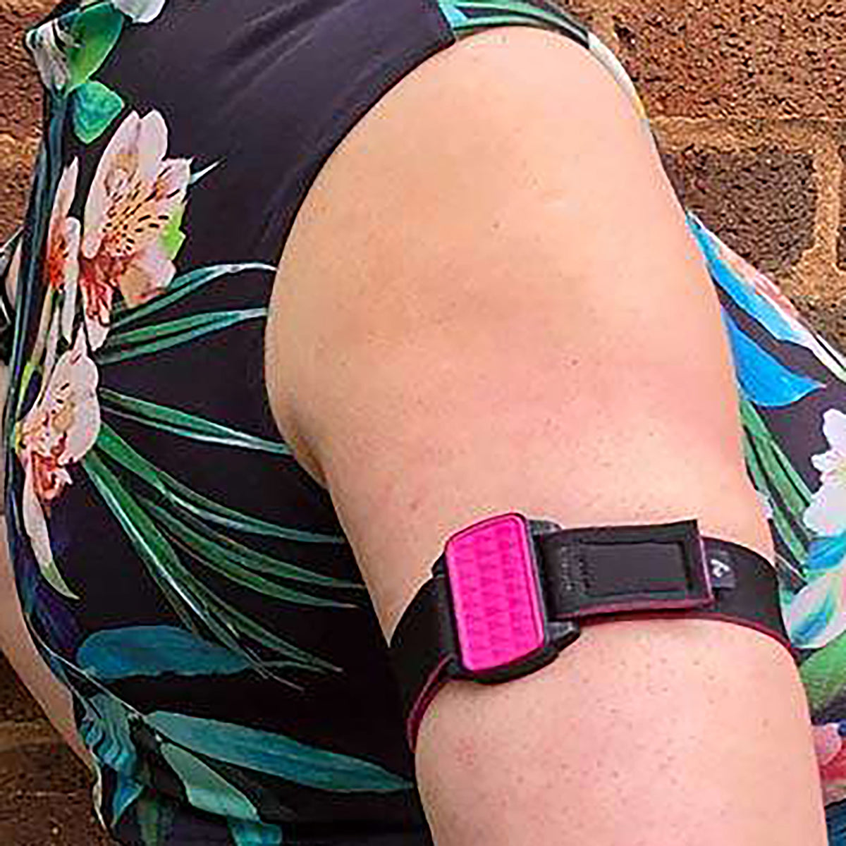 Dexband CGM armband for Dexcom G6 and ONE+ with magenta  cover and water-resistant neoprene strap worn on upper arm to help reduce risk of sensor being knocked off.