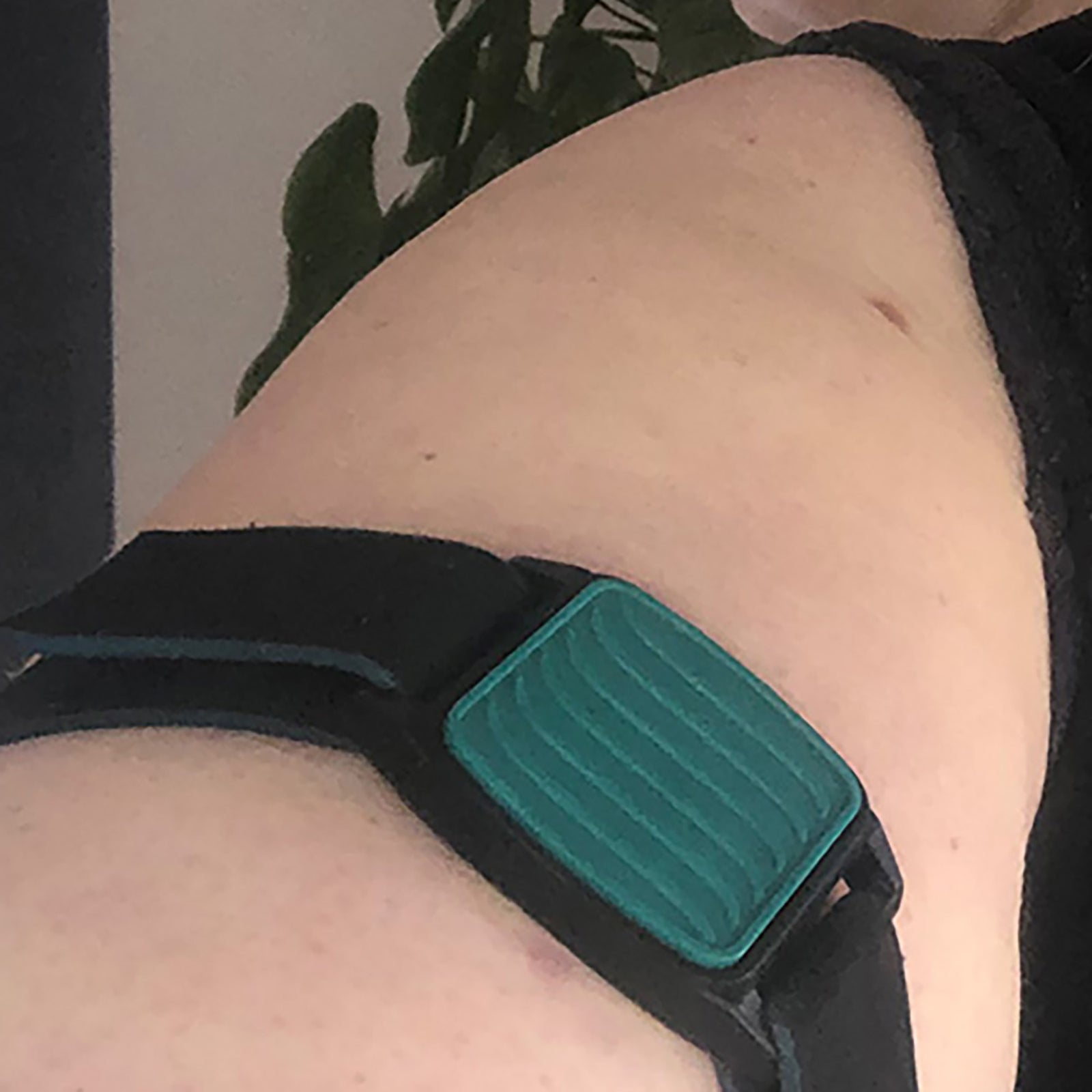 Dexband CGM armband with teal wave cover and neoprene strap, compatible with Dexcom G7 and ONE+ sensors, on wooden lounger in swimming pool setting.