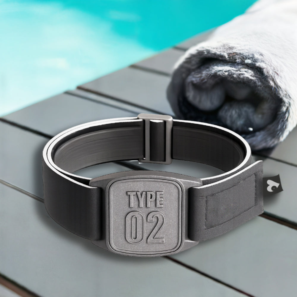 A pewter-colored neoprene armband with a 'TYPE 02' design, branded as Love My Libre Ltd, intended for use with a Freestyle Libre CGM. The armband is displayed on a wooden surface with a pool in the background.
