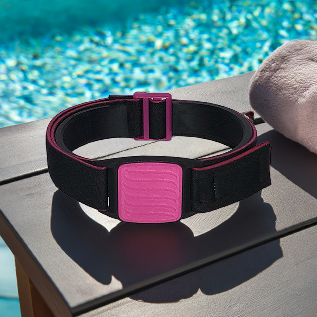 Dexband armband for Dexcom G7 CGM. Magenta cover with Wave design.  Shown on wooden table beside swimming pool.