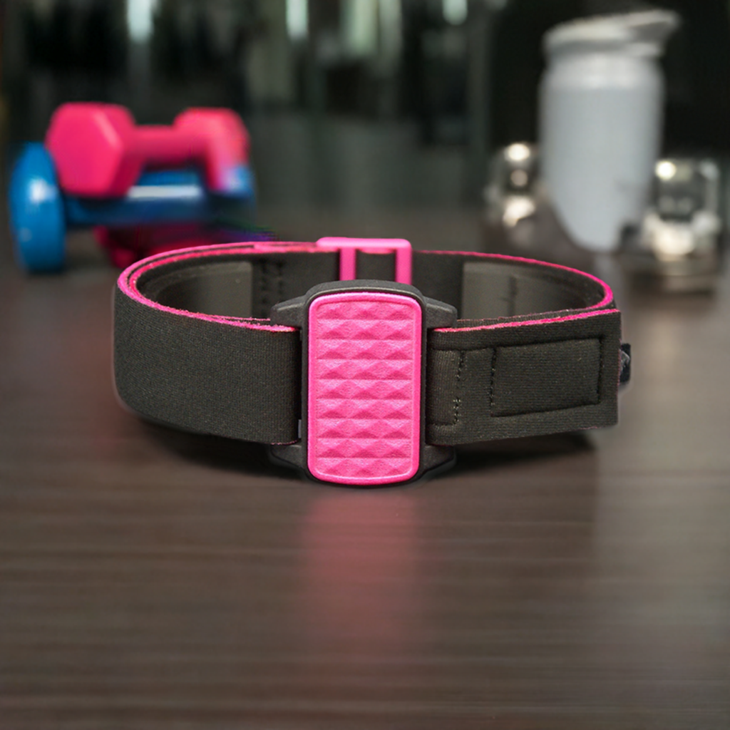 Dexband armband with magenta pyramids cover. Black strap edged in coordinating magenta. Gym equipment in background.