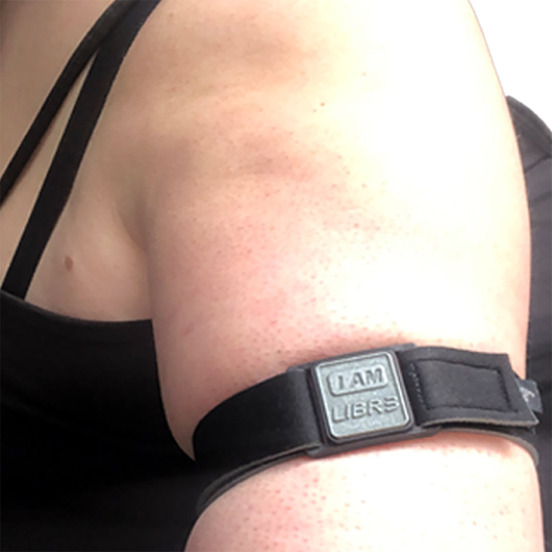 Model wearing Libreband armband for Freestyle Libre 3. Pewter cover with LIBR3 design.