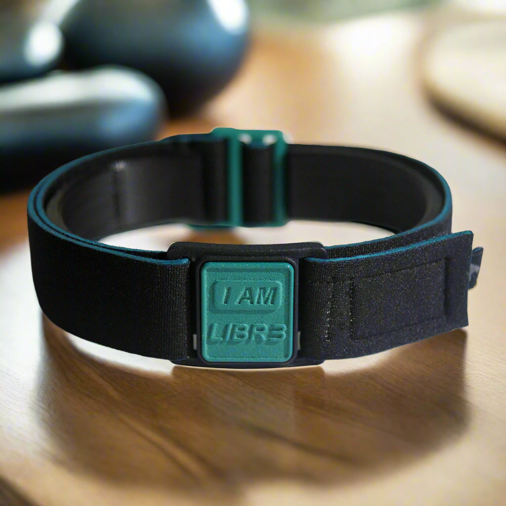 Libreband CGM armband for FreeStyle Libre 3 with teal I AM LIBR3 cover and water-resistant neoprene strap in gym setting. LML4801, LML4450, LML4443, LML4436.