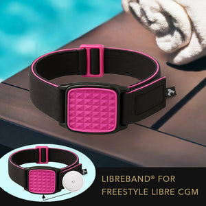 Libreband CGM armband for FreeStyle Libre 2 with magenta pyramids cover and water-resistant neoprene strap on wooden lounger in swimming pool setting. LML2821, LML2814, LML2883, LML4498.