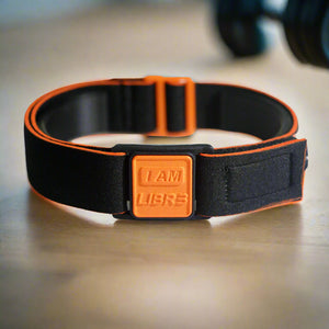 Libreband CGM armband for FreeStyle Libre 3 with orange I AM LIBR3 cover and water-resistant neoprene strap in gym setting. LML4764, LML4399, LML4382, LML4375.